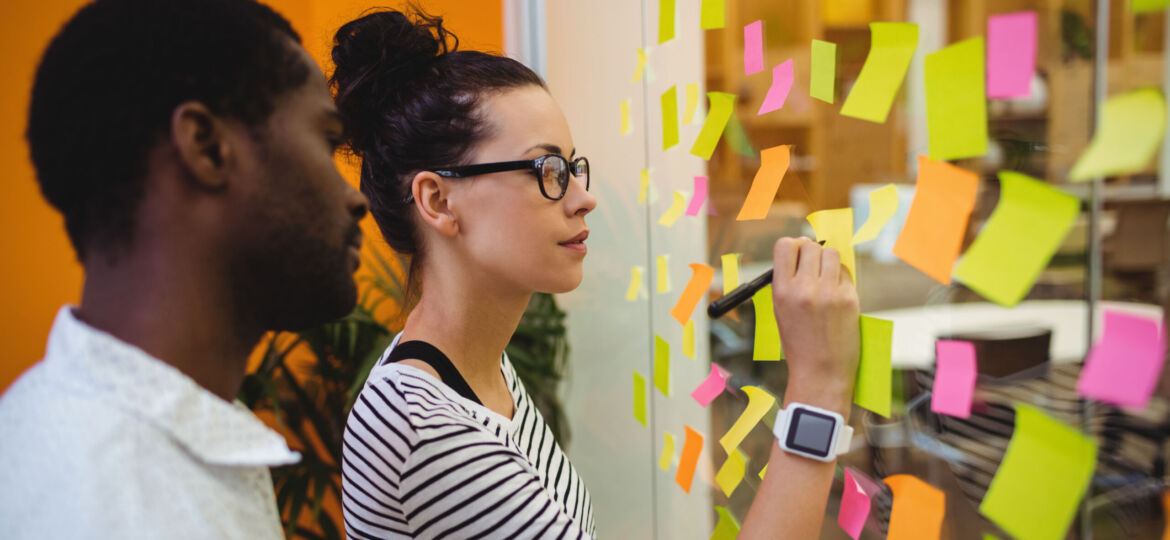 Business executives writing on sticky notes