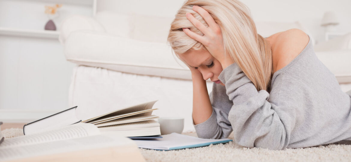 Attractive blond woman frustrated with her books