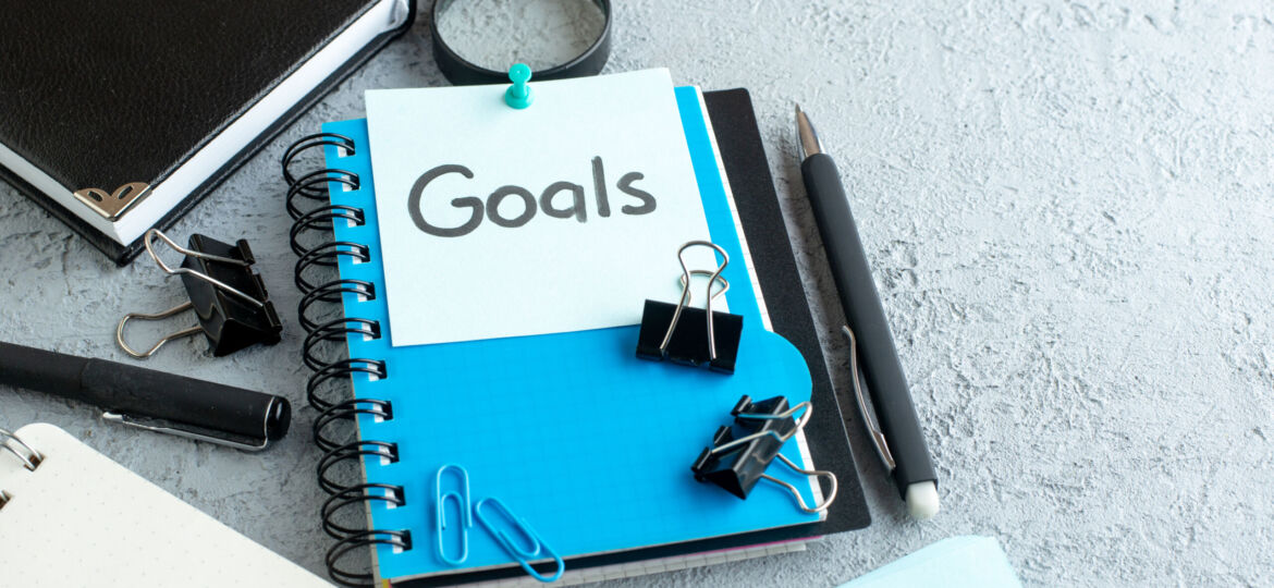 front-view-goals-written-note-with-notepad-pen-white-background